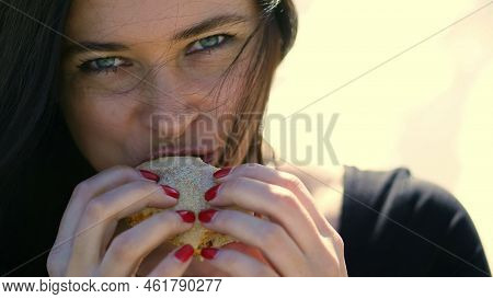 Summer, Outdoors. Portrait Of Beautiful Brunette Woman, With Dark Hair, With Apetite Eating Fastfood