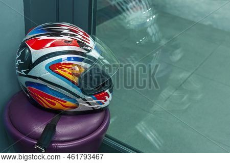 A Colourful Motorcyclist Helemet Abandoned On Bench, Indoor Closeup
