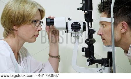 Female Doctor Optometrist, Ophthalmologist With Non Contact Tonometer Is Cheking Patients Vision, In