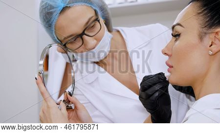 Medical Office, Beautiful Woman Looking In The Mirror, Doctor Wipes Patient Lips With A Sterile Napk