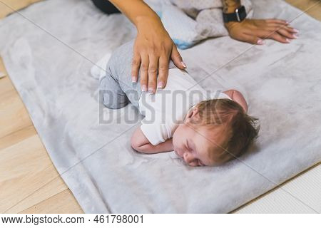 Little Infant Baby Boy In White T-shirt And Grey Sweatpants Lying On His Belly On Special Light Grey