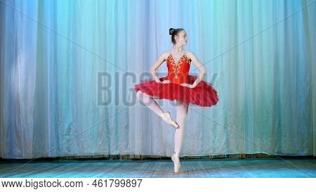 Ballet Rehearsal, On The Stage Of The Old Theater Hall. Young Ballerina In Red Ballet Tutu And Point