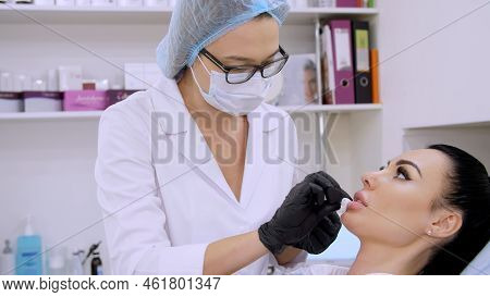 Cosmetology Room In The Clinic, The Doctor Wipes Patient Lips With A Sterile Napkin, Before Injectio
