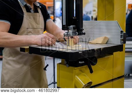 Professional Man Carpenter Using Electric Bandsaw Tool, Cutting Piece Of Wood At Workshop. Design, C