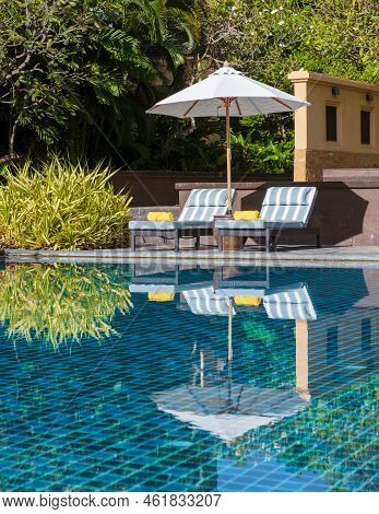Tropical Pool With Palm Trees And Beach Bed Chairs, Beach Chairs With Beach Towel At A Pool