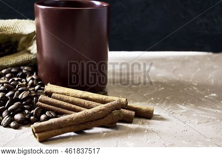 Coffee Beans Spilled Out Of A Canvas Bag Of Cinnamon And A Coffee Mug Onto A Table With A Place Of C