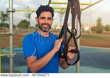 Portrait Of Confident Caucasian Man During Workout With Suspension Trx On Street
