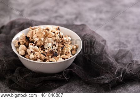 Burnt Popcorn In The Small White Bowl On Grey Ceramic