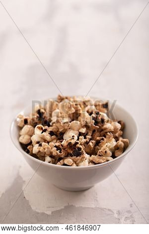 Burnt Popcorn In The Small White Bowl On Grey Ceramic