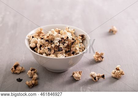 Burnt Popcorn In The Small White Bowl On Grey Ceramic