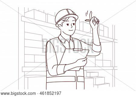 Man In Uniform And Helmet Working In Warehouse. Smiling Male Engineer Or Mechanic At Storehouse Or D