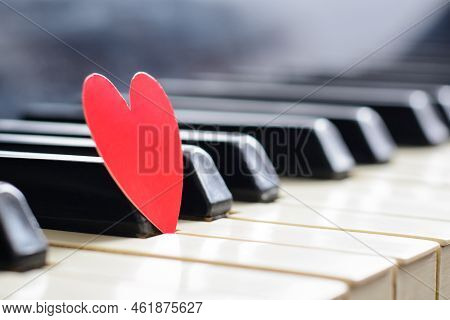 Small Red Heart On Piano Keyboard. Concept Of Love, Valentine's Day