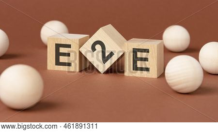 Wooden Cubes With Word E2e - End To End, Exchange To Exchange - And Wooden Balls On Brown Background