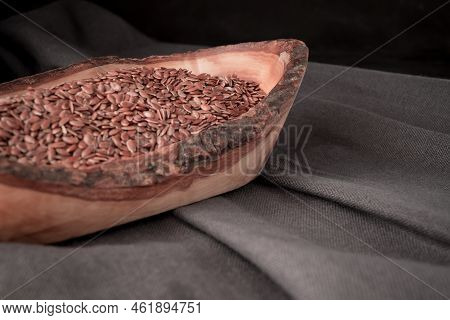 Flax Seeds In Wooden Spoon On Dark Background