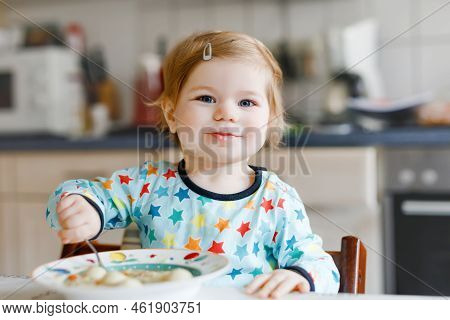 Adorable Baby Girl Eating From Spoon Vegetable Noodle Soup. Food, Child, Feeding And Development Con