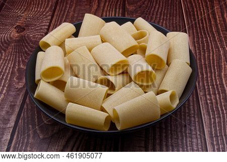Traditional Italian Uncooked Paccheri Pasta From Gragnano On Wooden Table.