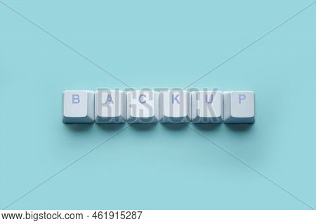 Word Backup Written On Computer Keyboard Keys Isolated On A Turquoise Background.