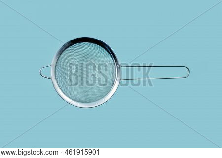 Stainless Steel Strainer For Filtering Tea With Water Isolated On Turquoise