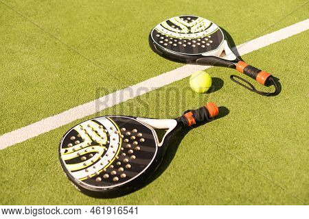 Yellow Balls On Grass Turf Near Padel Tennis Racket Behind Net In Green Court Outdoors With Natural 