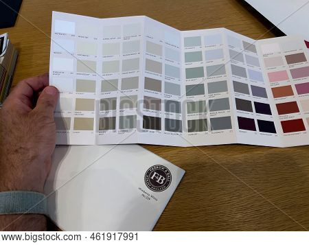 Paris, France - Aug 23, 2022: Personal Perspective Male Hand Holding Swatch Of Colors From Farrow An