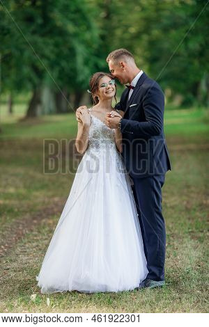 Vertical Merry, Glad, Chancy Smiling Married Couple Of Young Wife In Glasses And Husband Embracing I