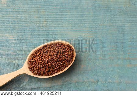 Spoon With Buckwheat Tea Granules On Light Blue Wooden Table, Top View. Space For Text