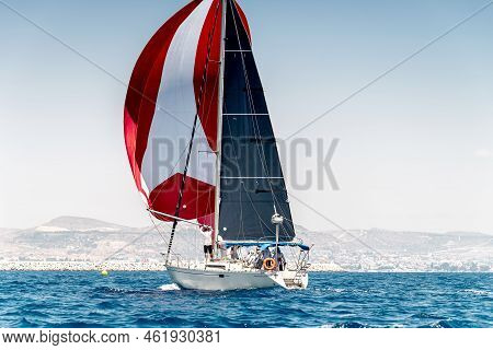 Sailing Boat On A Calm Water With Red Sail During The Regatta