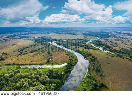 Beautiful Ukrainian nature background. Drone view on riverbank of the Seym river and amazing cloudscape over it. Summertime.