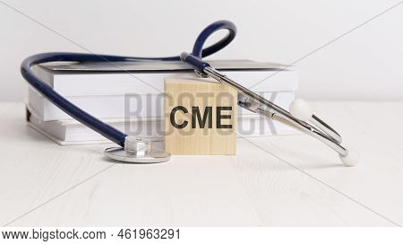 Wooden Block With Text Cme, Stethoscope And Notepad On White Background. Medical Concept