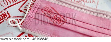Pink Medical Mask With Omicron Print. Different New Stamps Coronavirus Infection Concept