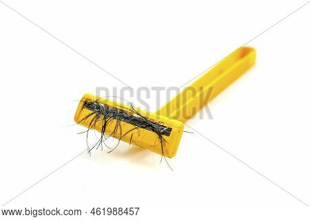 Used Yellow Shaver Has Hair Residue Stuck To It Isolated On White Background.
