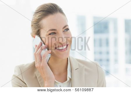 Close-up of a young businesswoman using mobile phone in a bright office