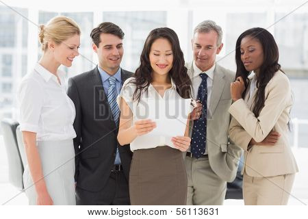 Business team looking at sheet of paper together in the office