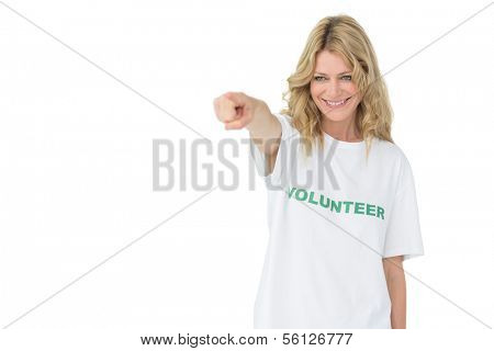 Portrait of a happy female volunteer pointing at you over white background