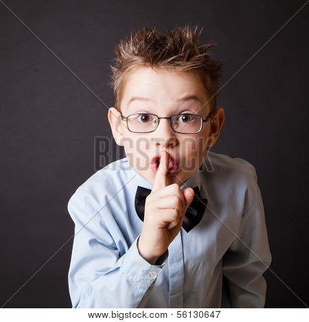 Little boy making sign to keep silence