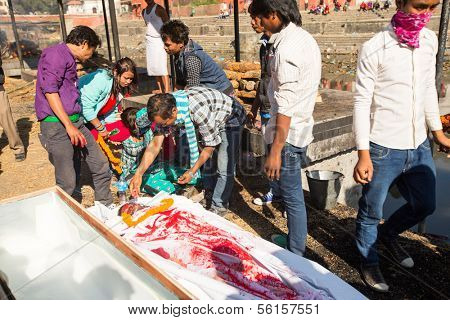 KATHMANDU, NEPAL - DEC 3: Unidentified local people during the cremation ceremony along the holy Bagmati River in Bhasmeshvar Ghat at Pashupatinath temple, Dec 3, 2013 in Kathmandu, Nepal.