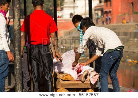 KATHMANDU, NEPAL - DEC 3: Unidentified local people during the cremation ceremony along the holy Bagmati River in Bhasmeshvar Ghat at Pashupatinath temple, Dec 3, 2013 in Kathmandu, Nepal.