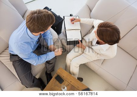 Business team working together on the couch scheduling in diary in the office
