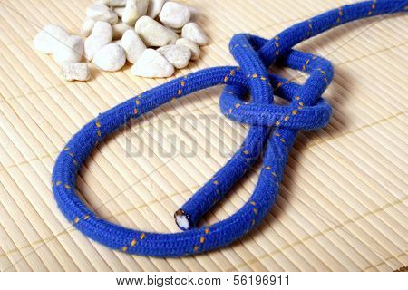 A fine knotted bowline next to a pile of stones