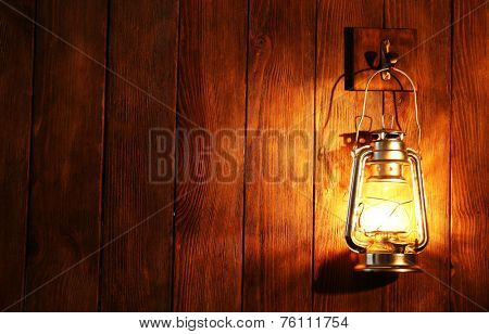 Lantern hanging on hook on wooden wall