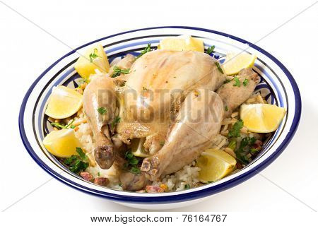 Chicken pilaf, or riz bi djaaj, traditional Arab and Mediterranean boiled chicken and rice dish, served with roasted nuts and lemon wedges.