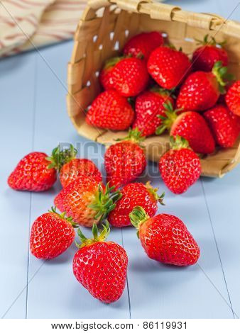 Basket With Strawberries Spilling On A Table