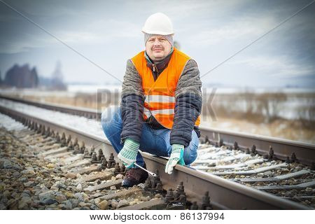 Worker with adjustable wrench on the railroad