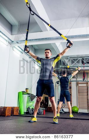 Crossfit instructor at the gym doing TRX Excersise