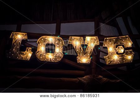 Inscription Love By Electric Bulb On The Wood Blackboard