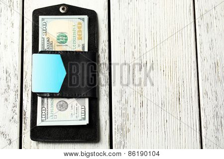 Hand made leather man wallet with money on white wooden background