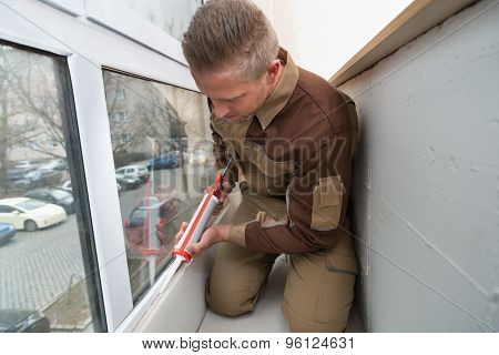 Worker Applying Glue With Silicone Gun