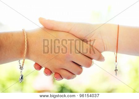 Two hands of friendship and religions symbols