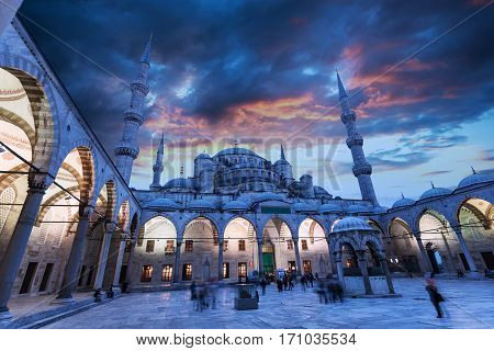Blue Mosque or Sultanahmet Camii in Istanbul with beautiful sunset sky and with night illumination. The view from the courtyard.