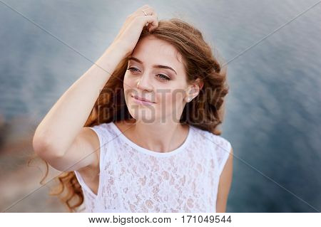 beautiful bride in a white dress on background of water.
